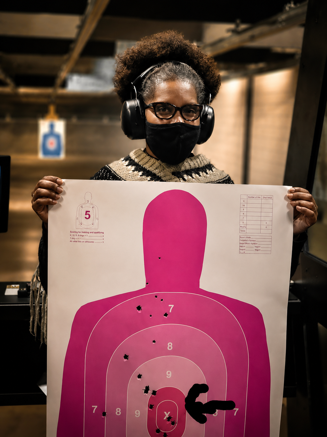 Student holding her scored silhouette target at the range